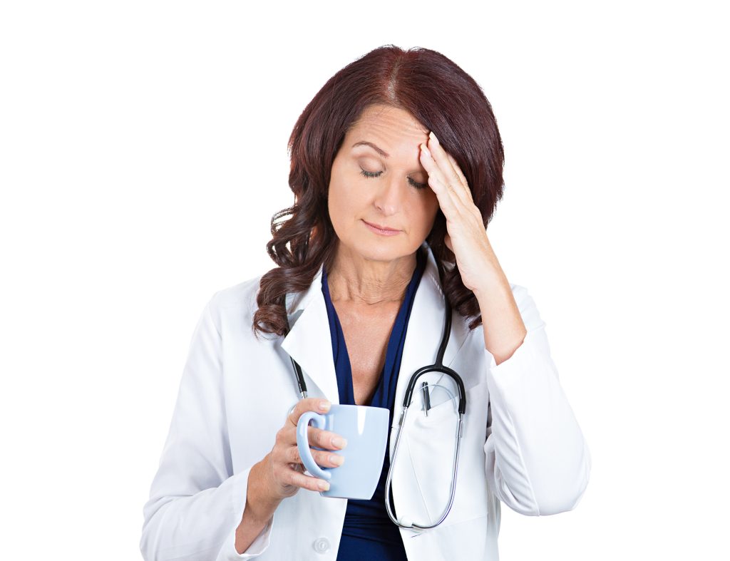 Closeup portrait sad unhappy health care professional with headache stressed sleepy holding cup of coffee isolated white background. doctor with migraine overworked overstressed. Face expression