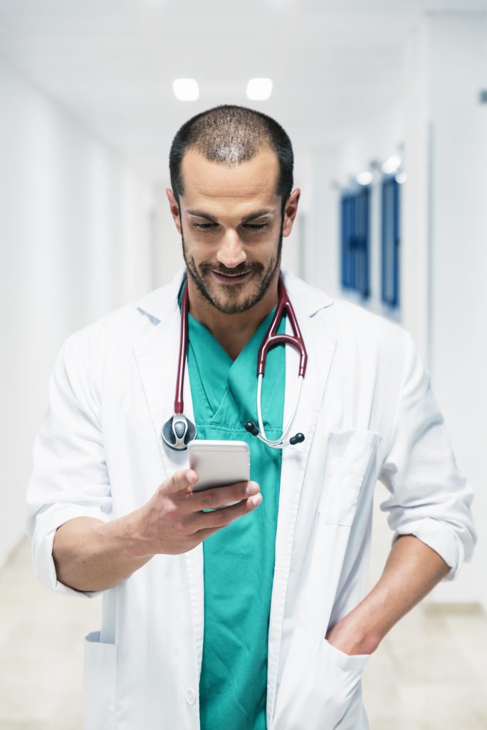 doctor looking at cellphone at hospital. Indoors