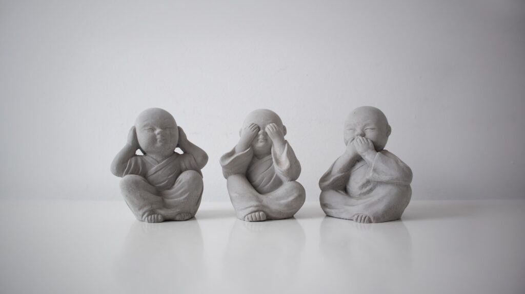 Three small statues of buddhas sitting in a row